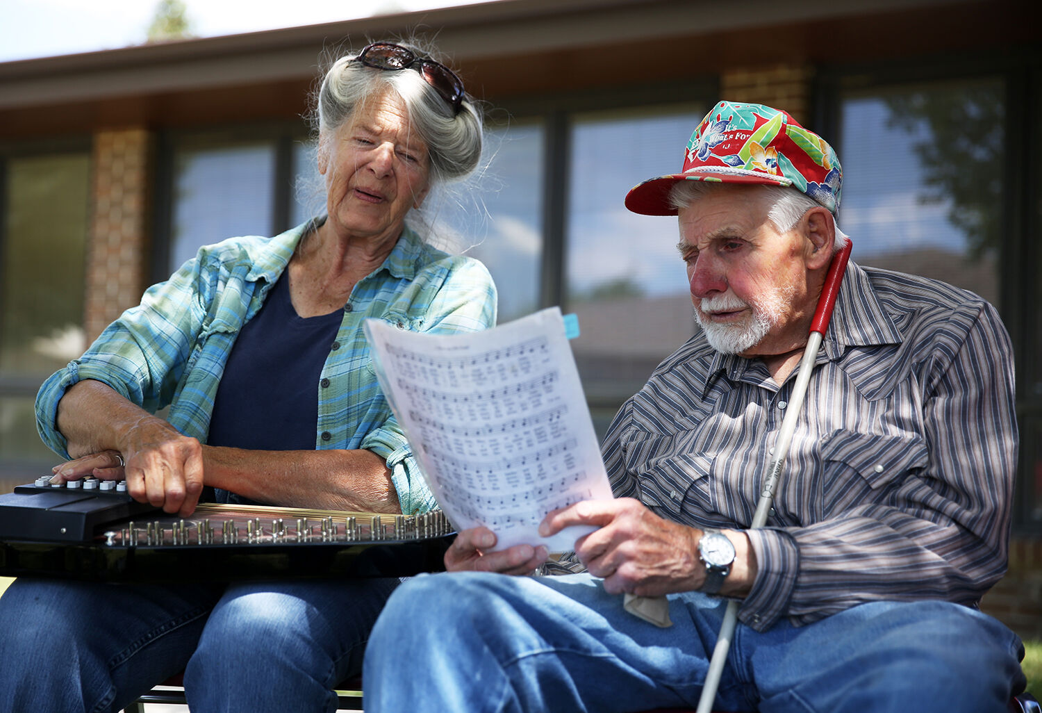Sue and Charlie Cook follow the written lyrics as they sing a song with the group